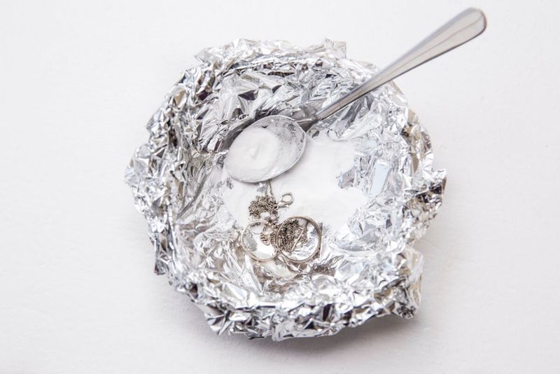 A Solution Of Baking Soda(sodium Bicarbonate) And Warm Water Will Remove The Tarnish From Silver When The Silver Is In Contact With A Piece Of Aluminium Tin Foil. Pouring Hot Water Over Silver.