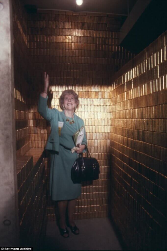 1974 Mrs. Mary Brooks, the Director of the Mint, in the midst of gold within one of Fort Knox's vaults.