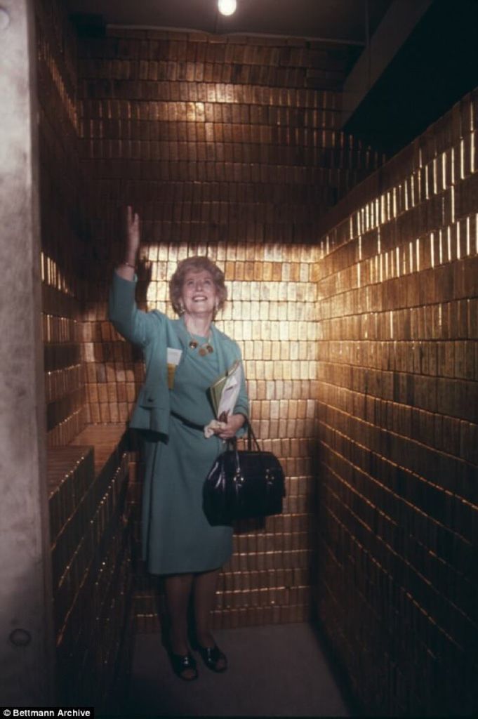 1974 Mrs. Mary Brooks, the Director of the Mint, in the midst of gold within one of Fort Knox's vaults.